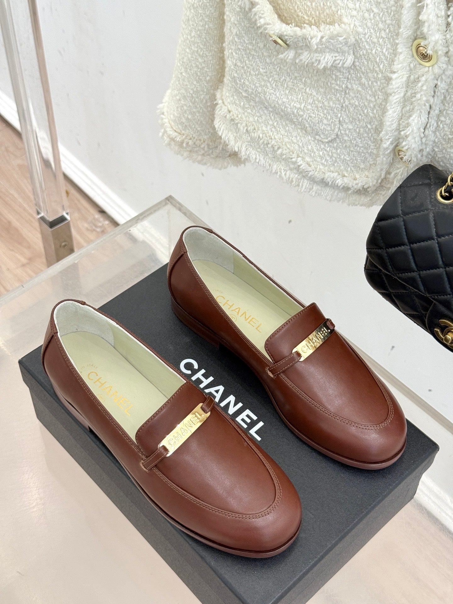 Women’s brown leather loafers with gold buckle strap, front view pair