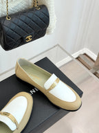 Chanel women's loafers side view, cream leather with white strap and gold buckle
