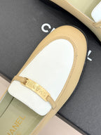 Chanel women's loafer close-up, white vamp with cream border and gold buckle