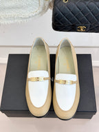 Chanel women's loafers front view, cream leather with white strap and gold buckle