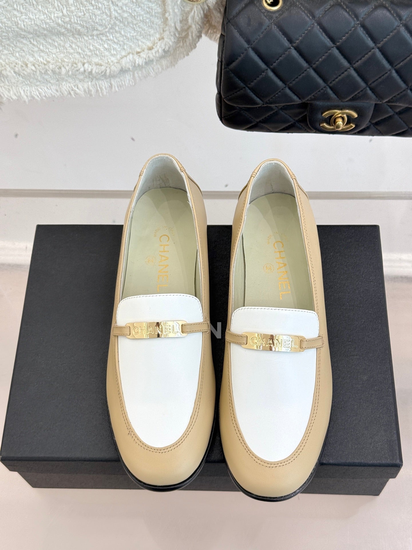 Chanel women's loafers front view, cream leather with white strap and gold buckle
