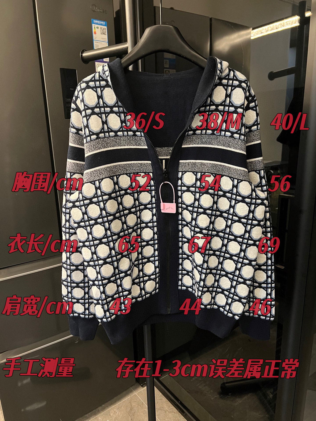 Zip-up hooded jacket with lattice pattern and dark center panel, shown on hanger