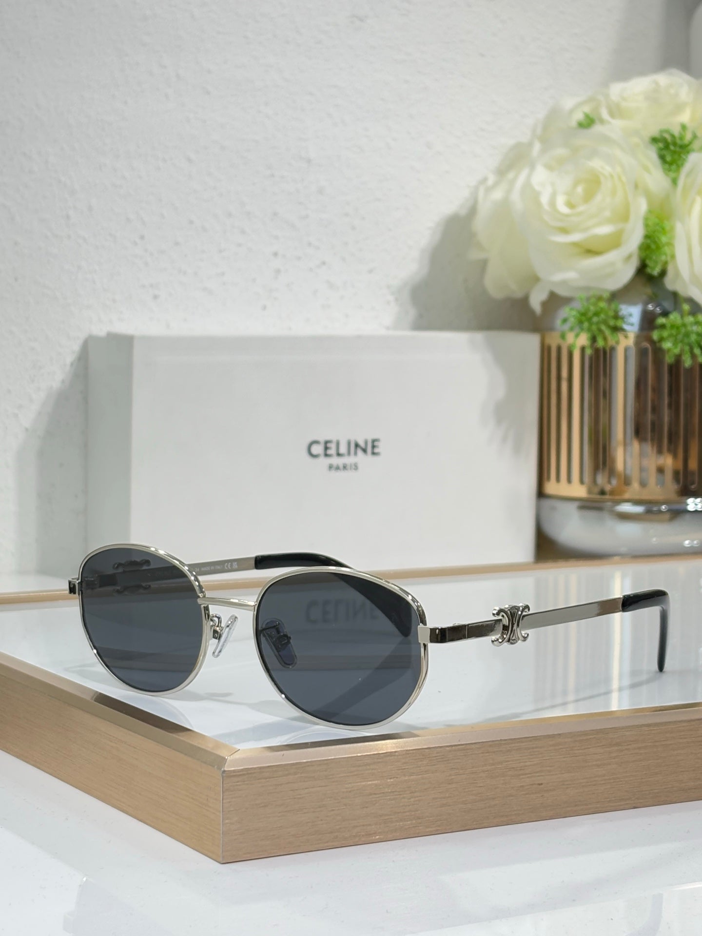 Black and gold round sunglasses with dark lenses and side hinge detail