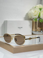 Gold round sunglasses with dark lenses and decorative hinge accents