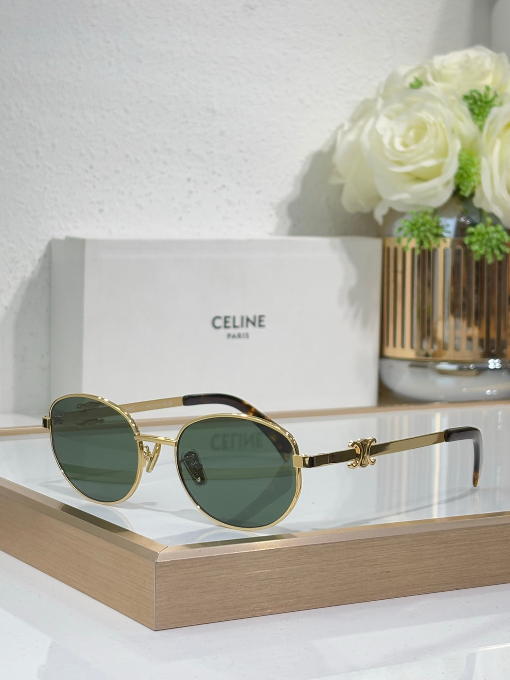 Gold round sunglasses with dark green-tinted lenses and metal temple arms