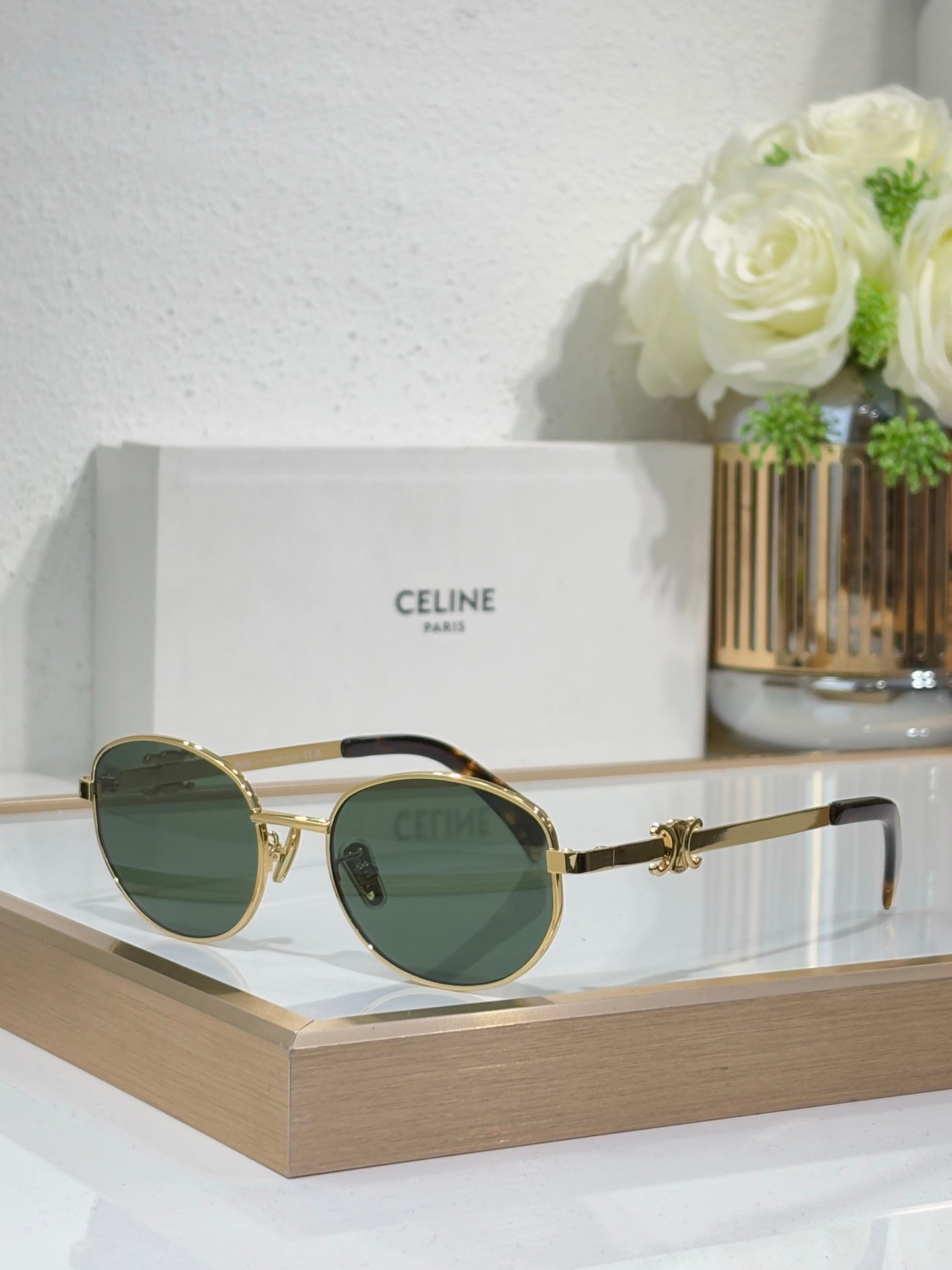 Gold round sunglasses with dark green-tinted lenses and metal temple arms