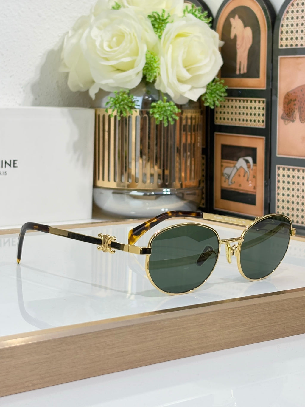 Gold round sunglasses with dark lenses, curved bridge, and metal arms