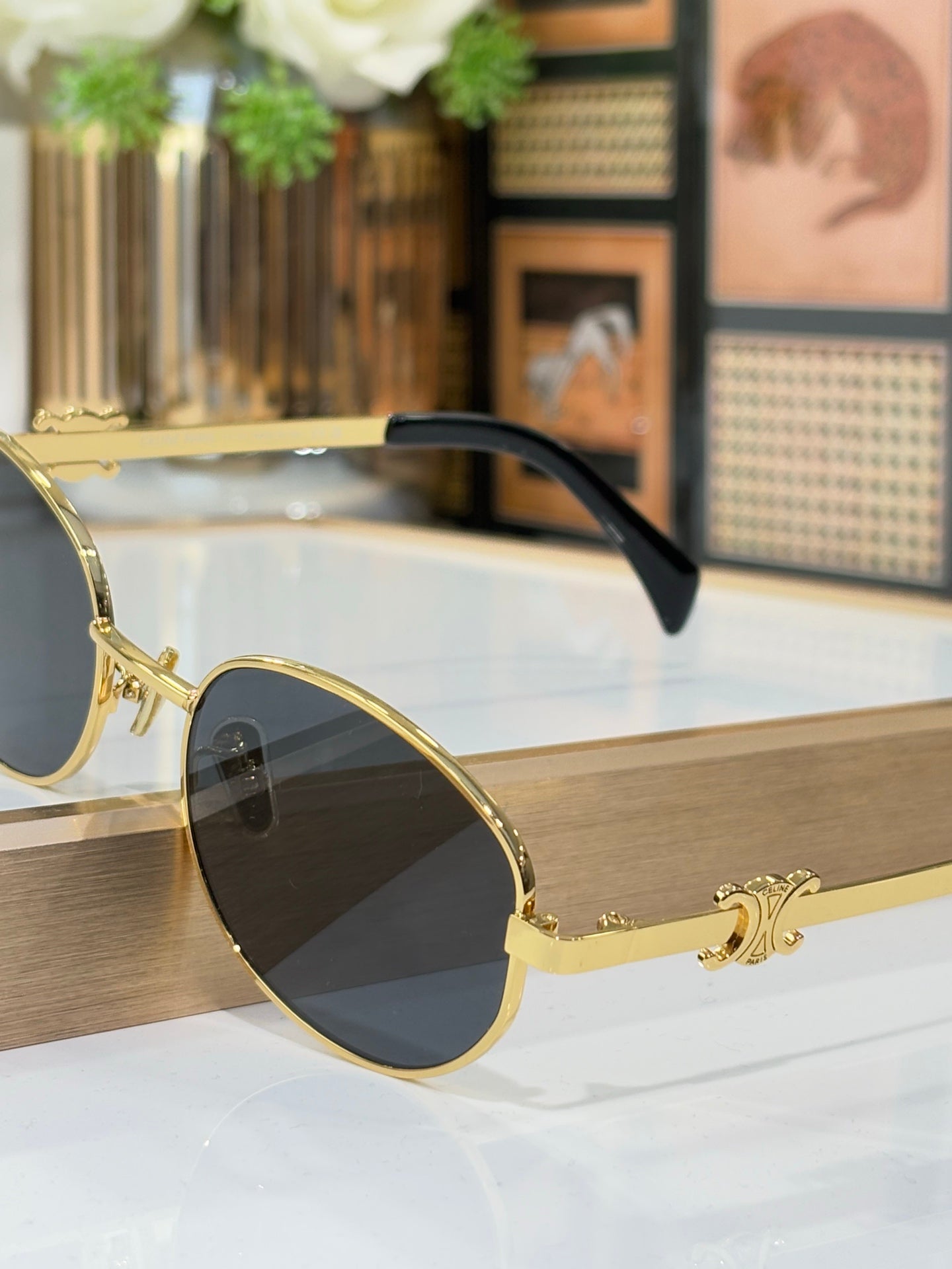 Celine round sunglasses with gold frame and dark lenses, black temple arm