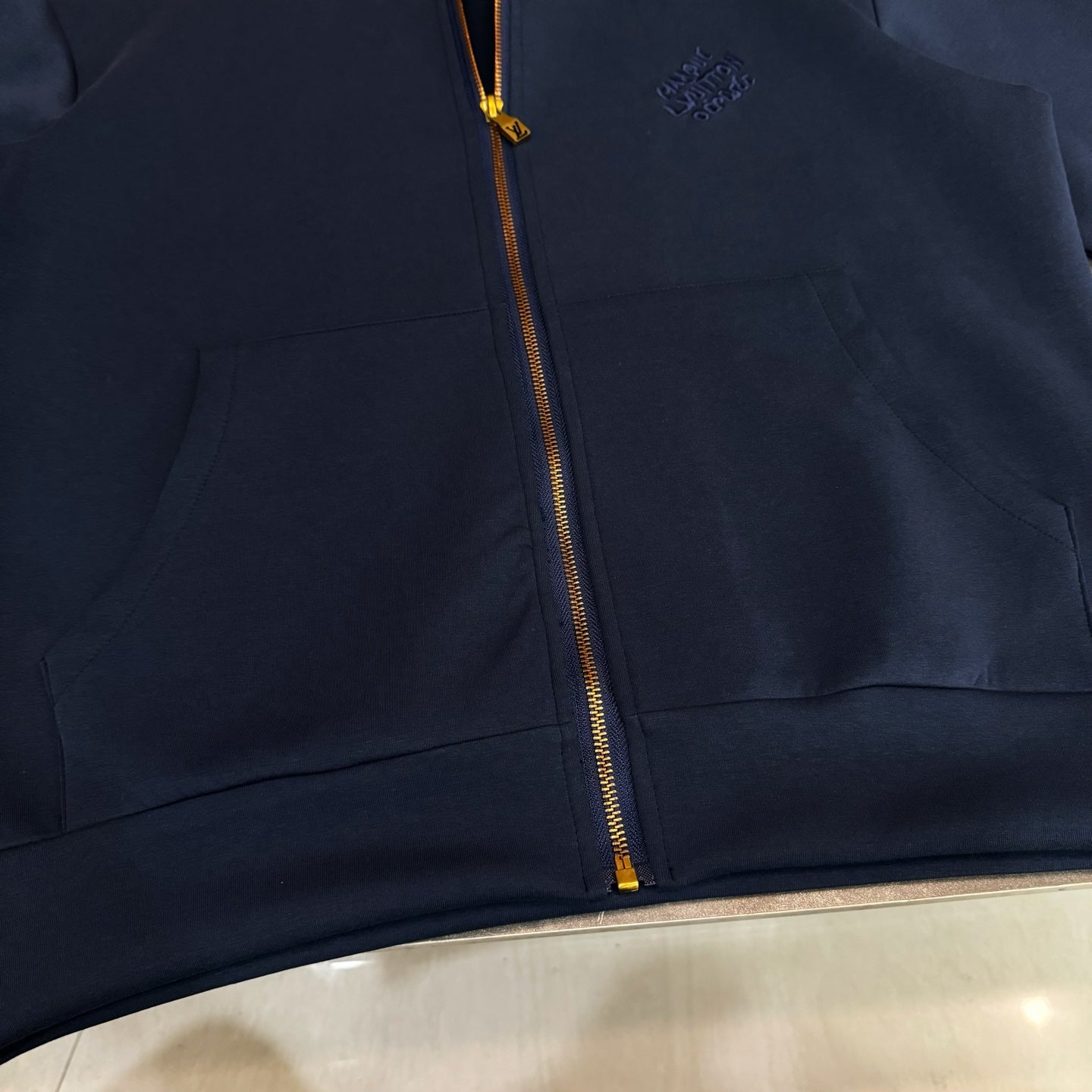 Navy Louis Vuitton zip-up hoodie with front pocket, small chest logo, and gold zipper