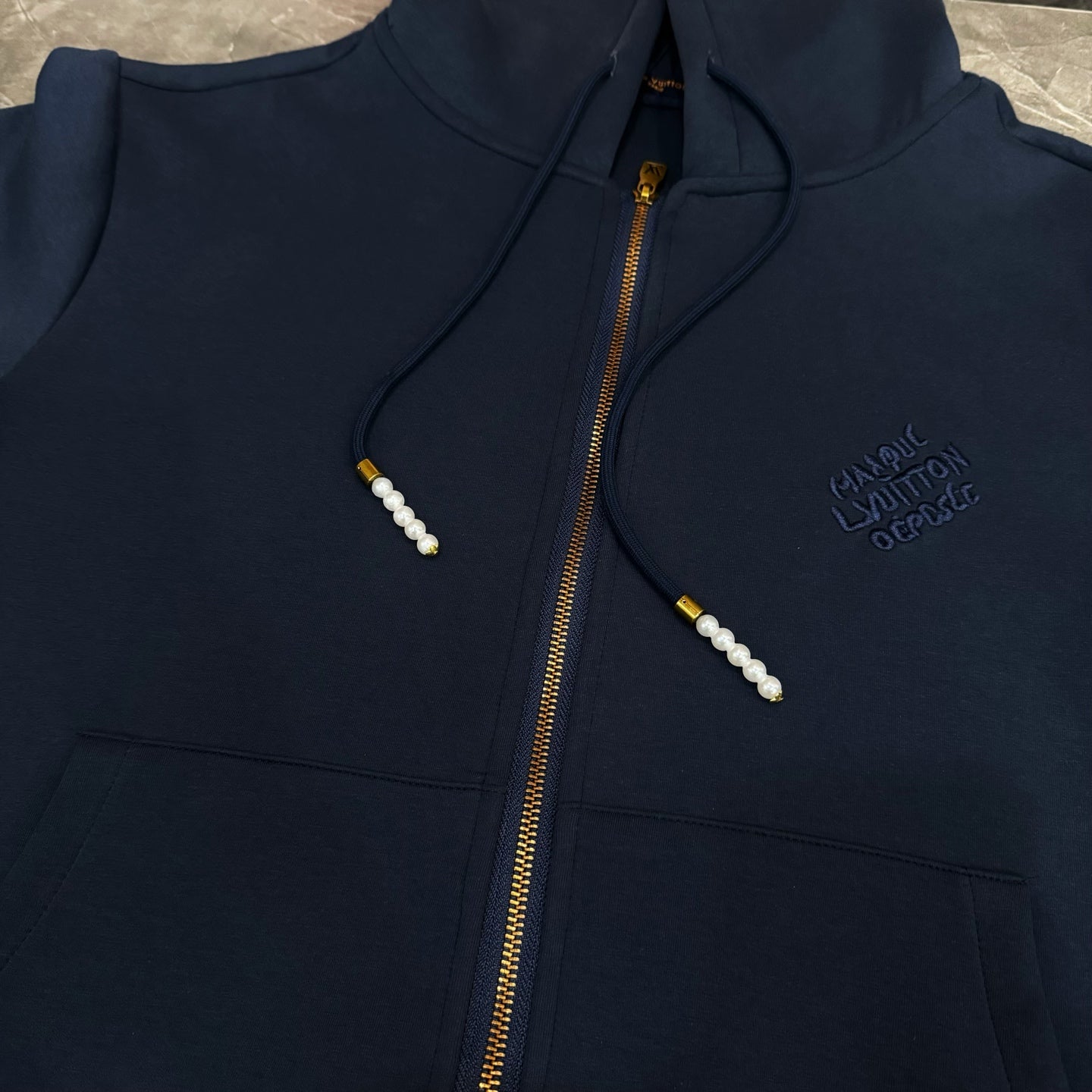 Navy Louis Vuitton zip-up hoodie with hood drawstrings, gold zipper, and chest logo