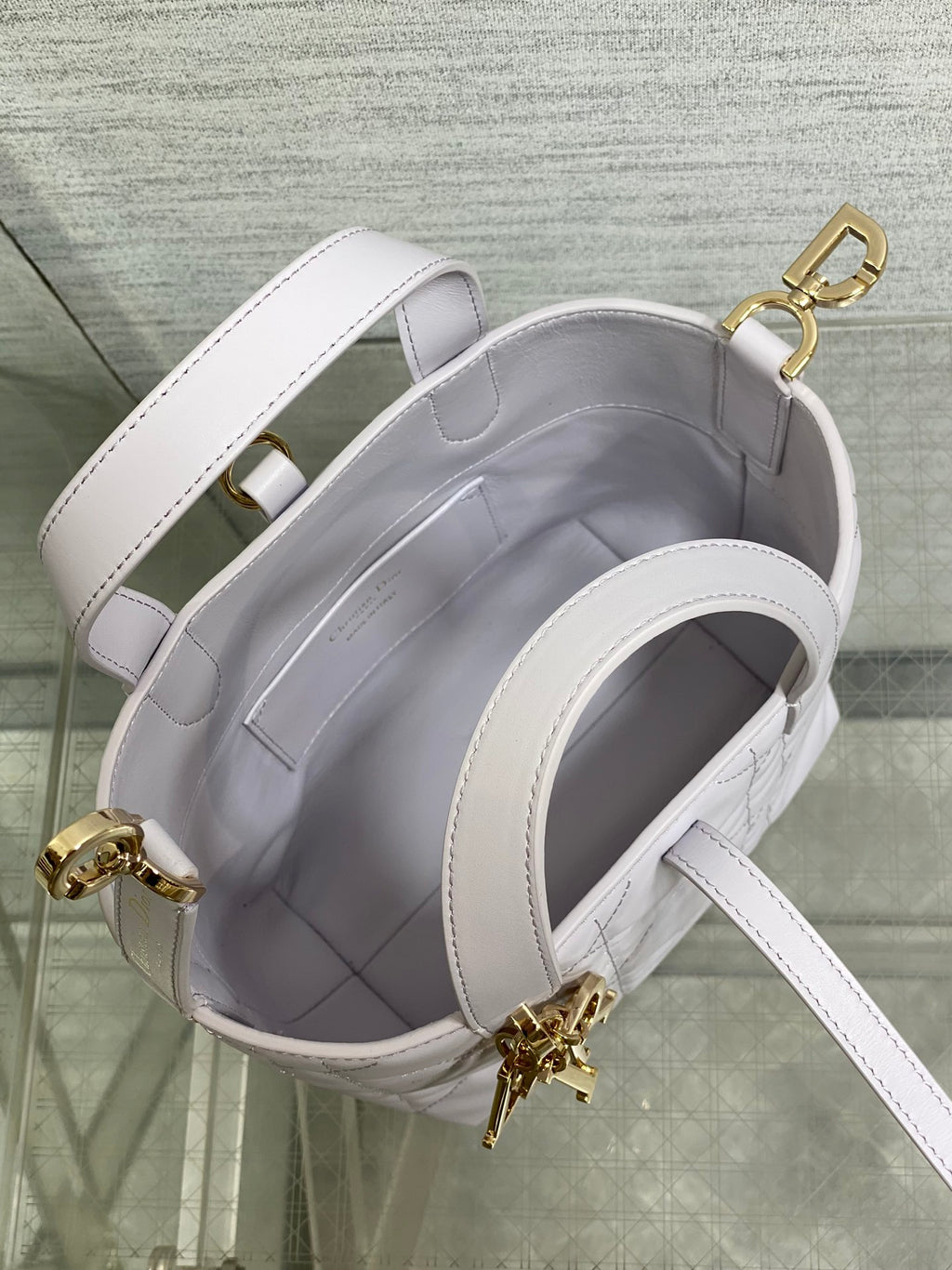 Dior quilted mini handbag interior view with light white leather lining and shoulder strap