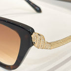Bvlgari sunglasses with glossy dark frame and gold rhinestone temple detail