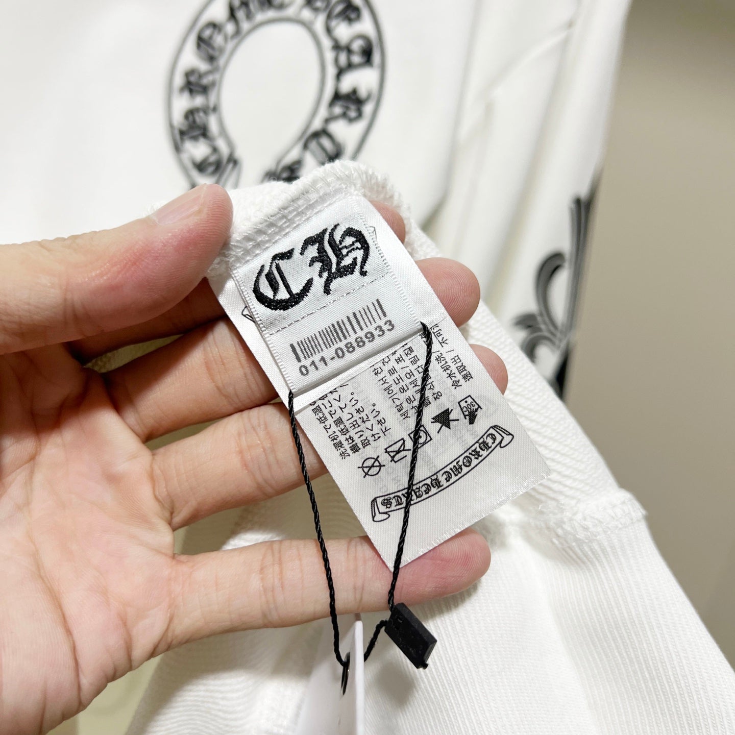 White sweatshirt sleeve with attached size and care label tag