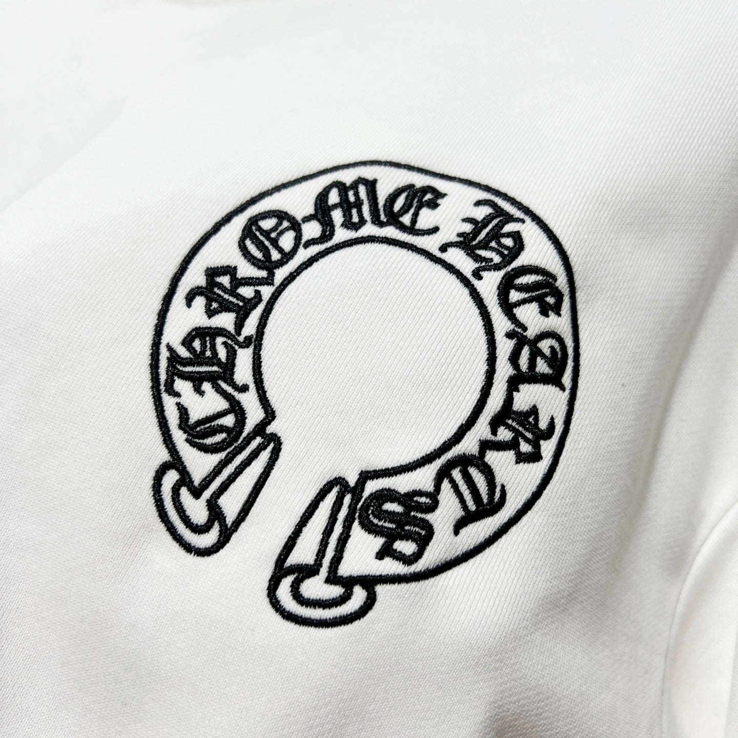 White sweatshirt chest graphic: circular black logo print