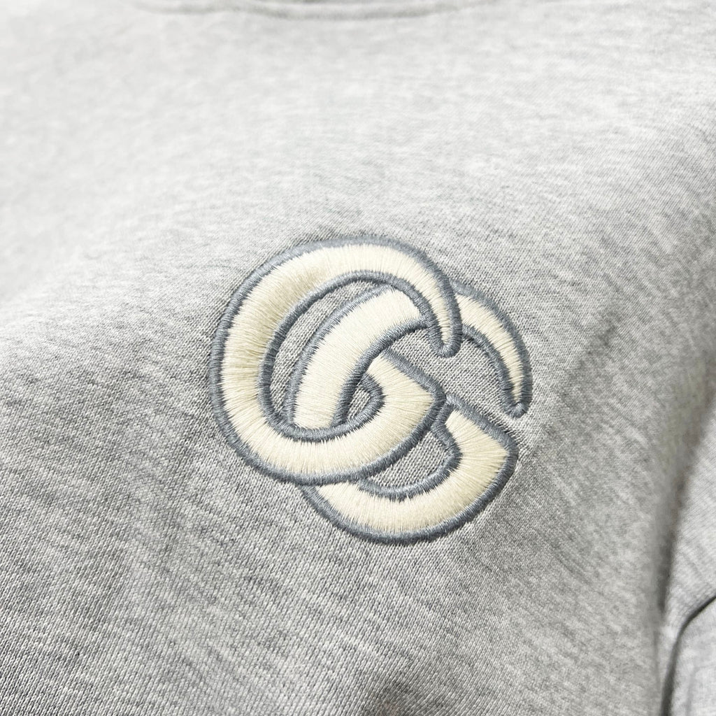 Gucci long-sleeve hoodie detail of embroidered GG logo on heather gray fabric