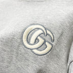 Gucci long-sleeve hoodie detail of embroidered GG logo on heather gray fabric