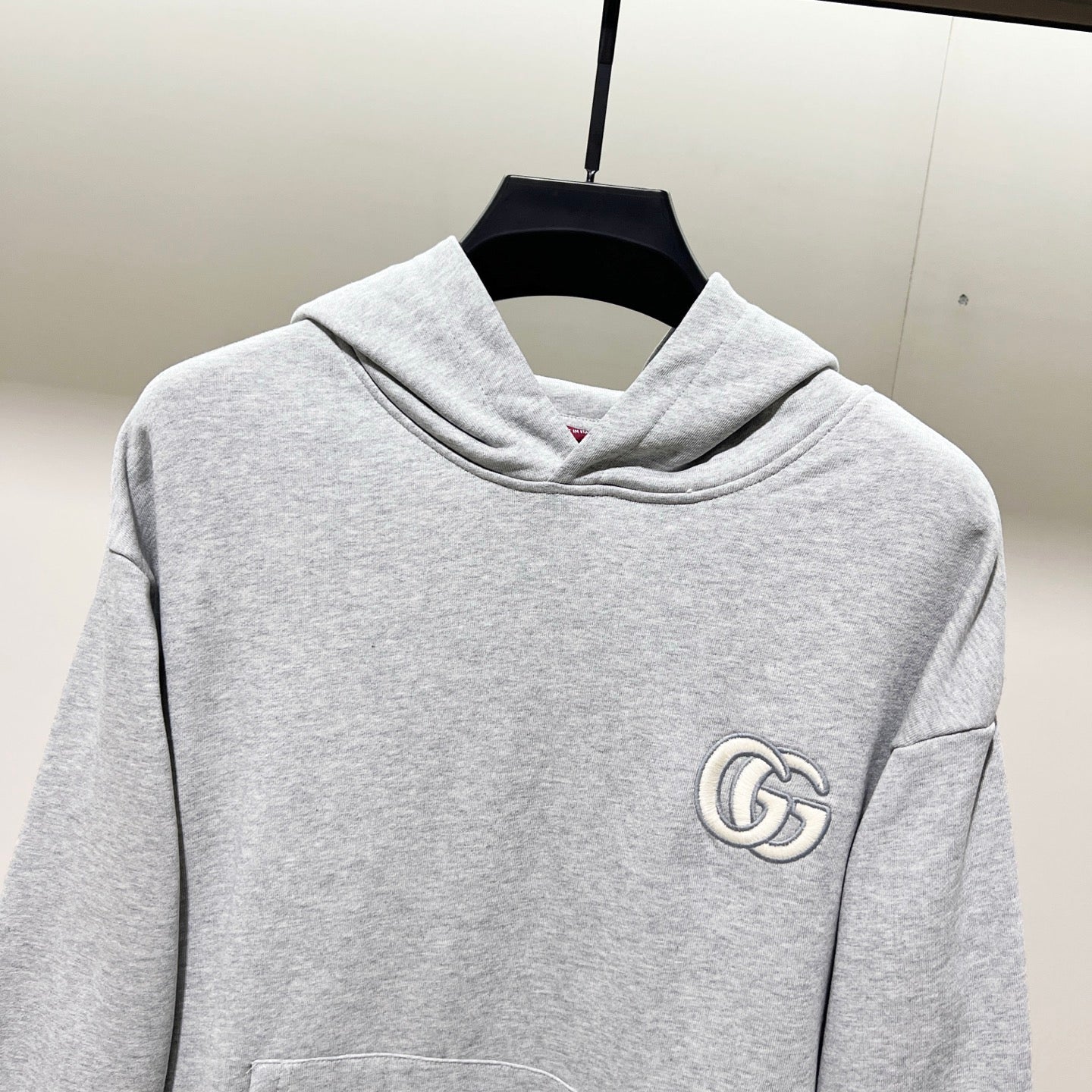 Gucci long-sleeve hoodie, heather gray, front view with circular chest GG logo patch