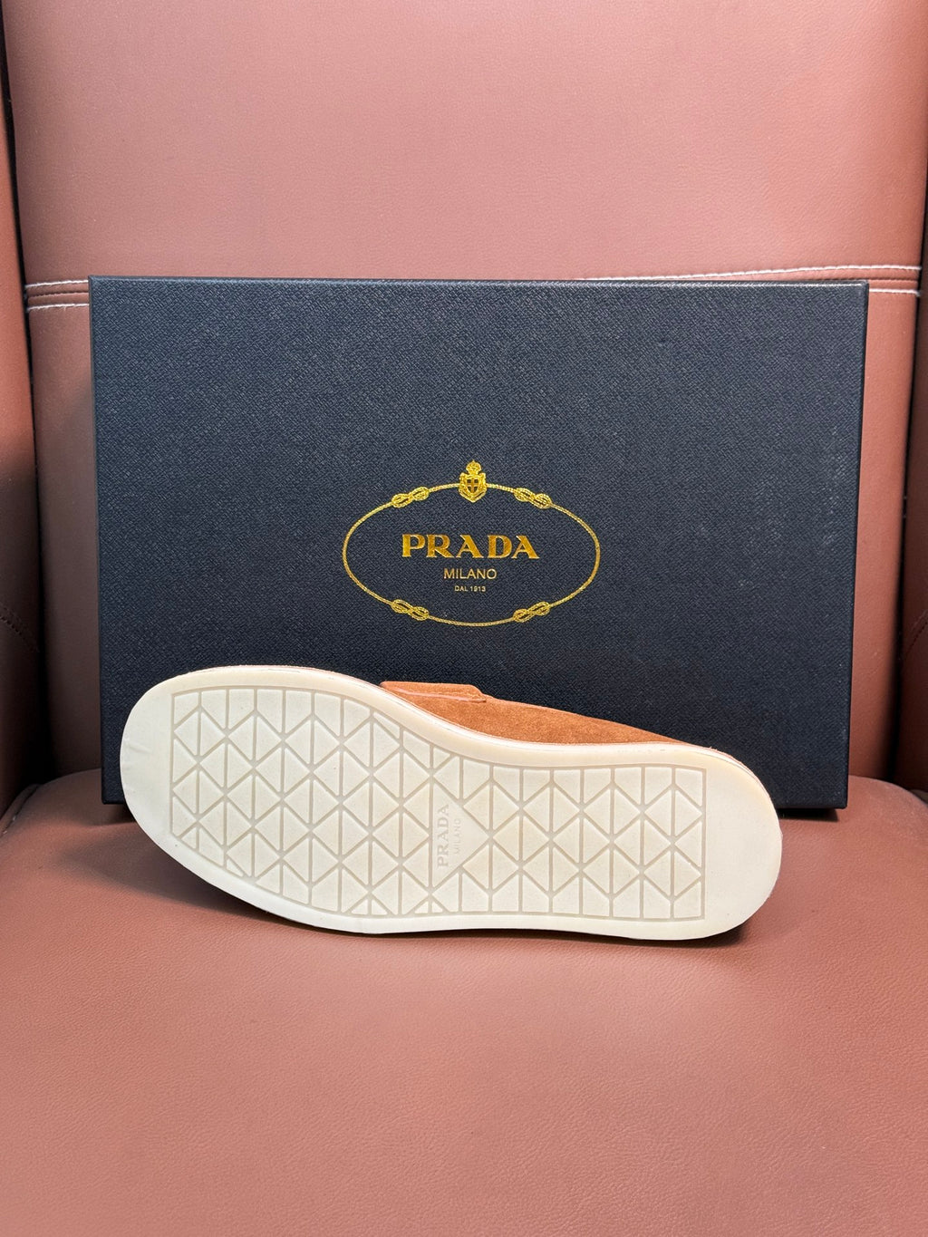 Prada unisex tan suede loafer outsole with textured white rubber tread.