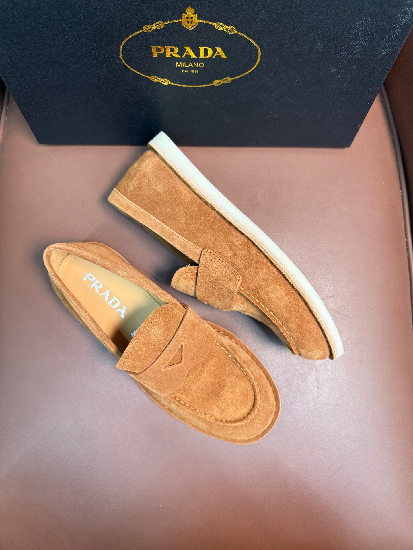 Prada unisex tan suede loafers with white rubber sole trim, side view pair.
