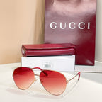 Gold-tone round sunglasses with red tinted lenses and red temple arms