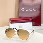 Gold-tone round sunglasses with warm brown tinted lenses and slim metal frame