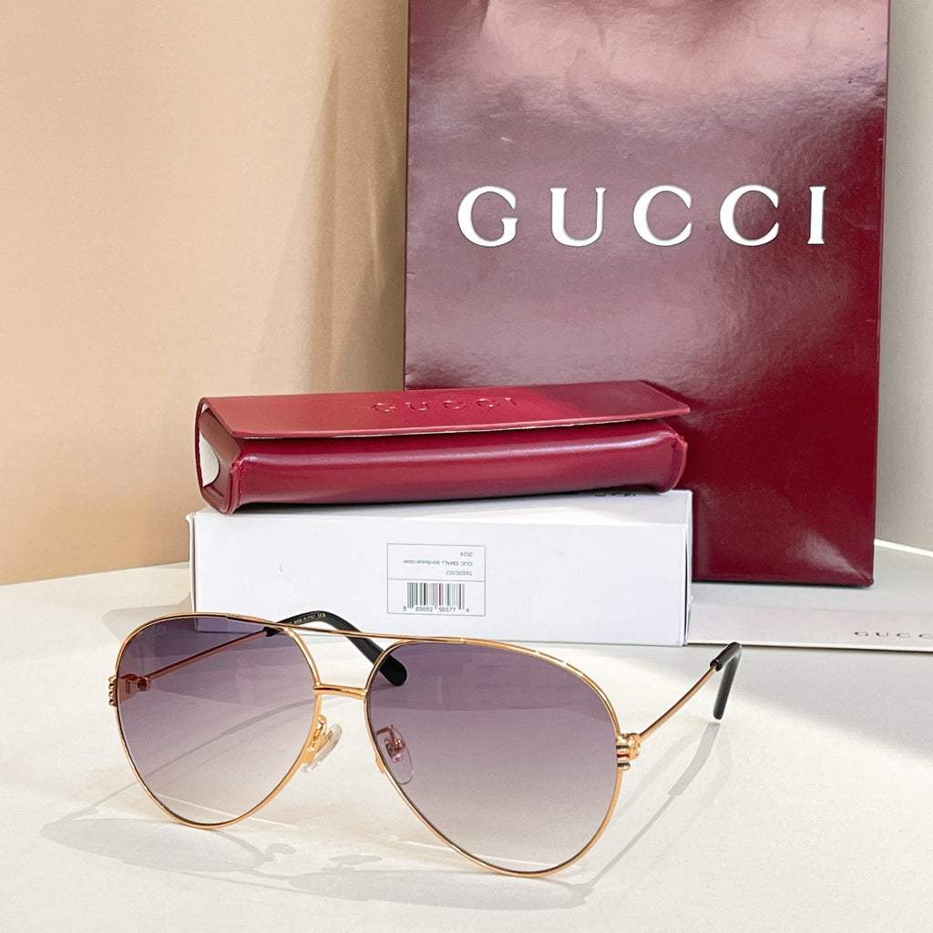 Gold-tone round sunglasses with tinted purple lenses and black logo detail on arms