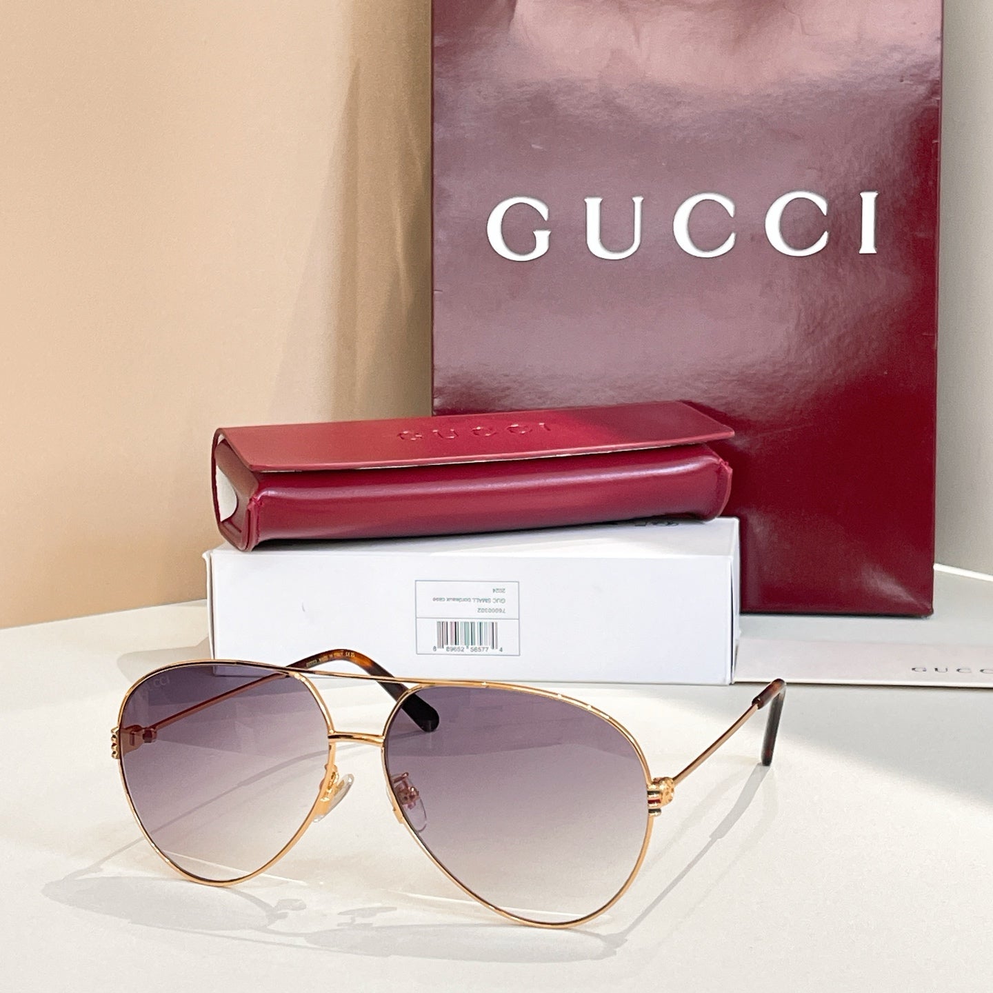 Gold-tone round sunglasses with tinted purple lenses and thin metal bridge