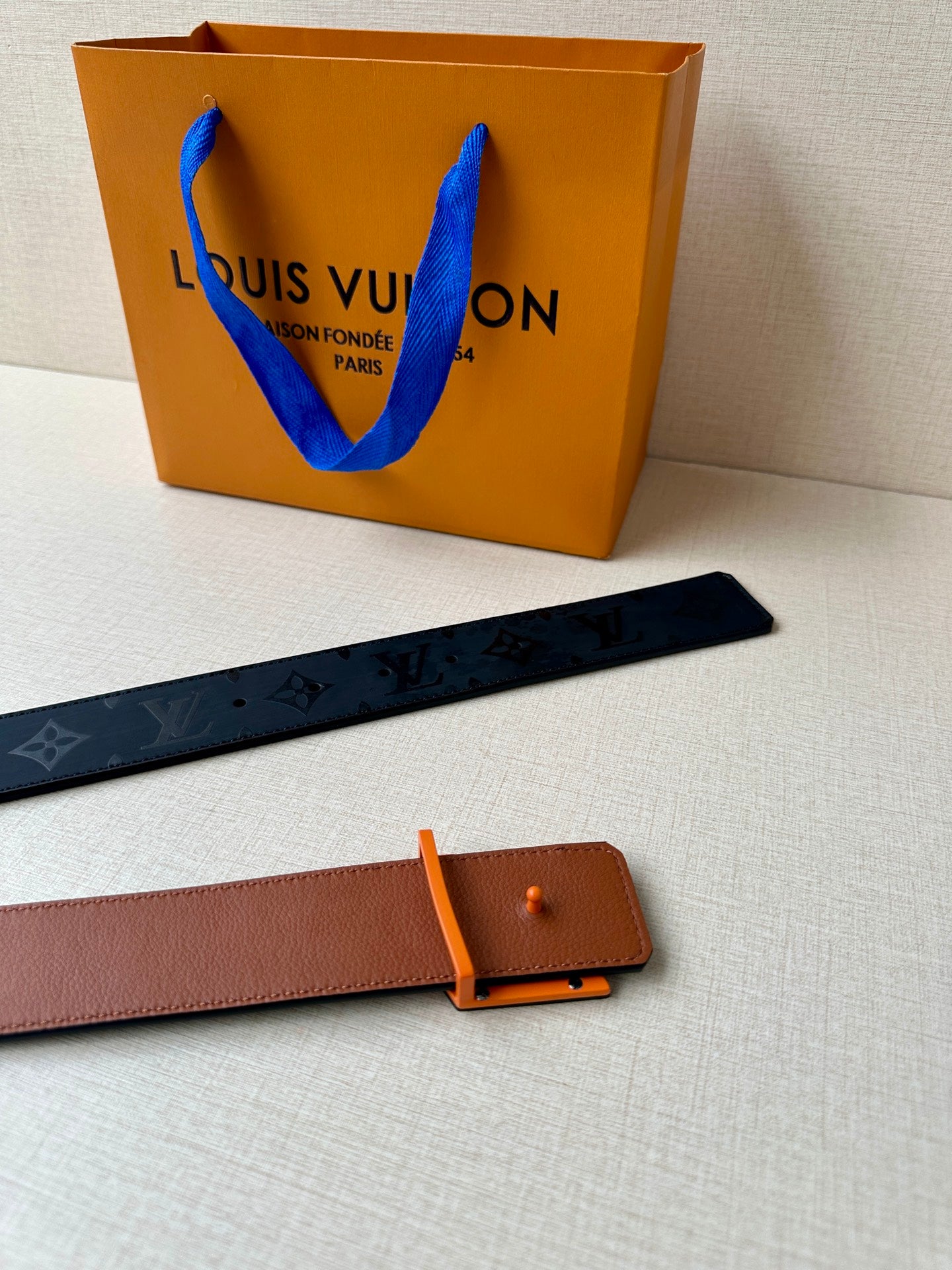Louis Vuitton belt: dark blue monogram strap and tan leather back strap with buckle.