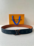 Louis Vuitton belt: dark blue monogram strap, tan lining, metal buckle.