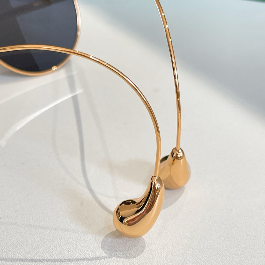 Bottega Veneta glasses close-up: gold frame with dark lens