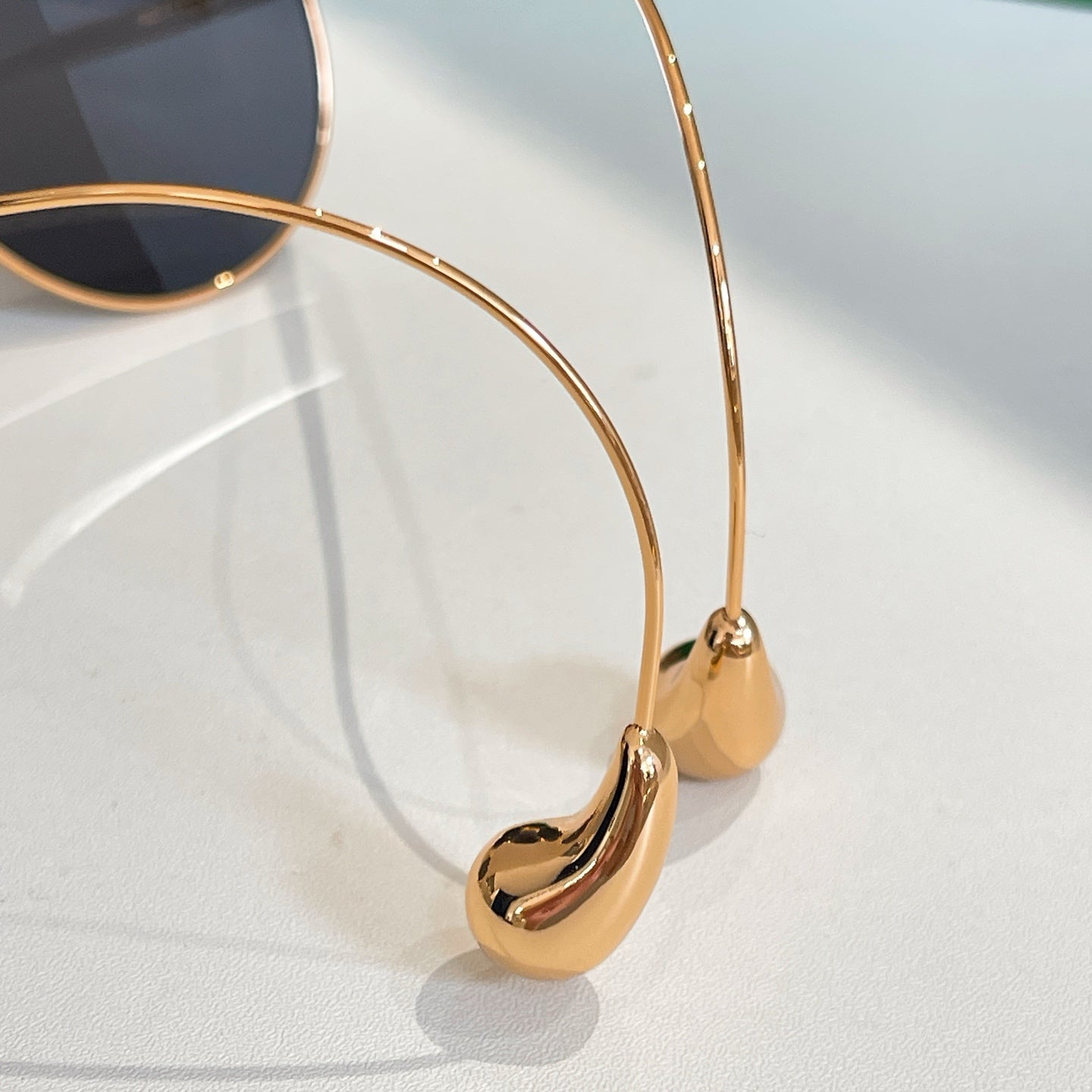 Bottega Veneta glasses close-up: gold frame with dark lens