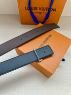 Dark navy leather belt with rectangular silver-tone buckle and keeper, laid across box