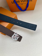 Dark navy leather belt strap with rows of holes and white-and-pink monogram buckle