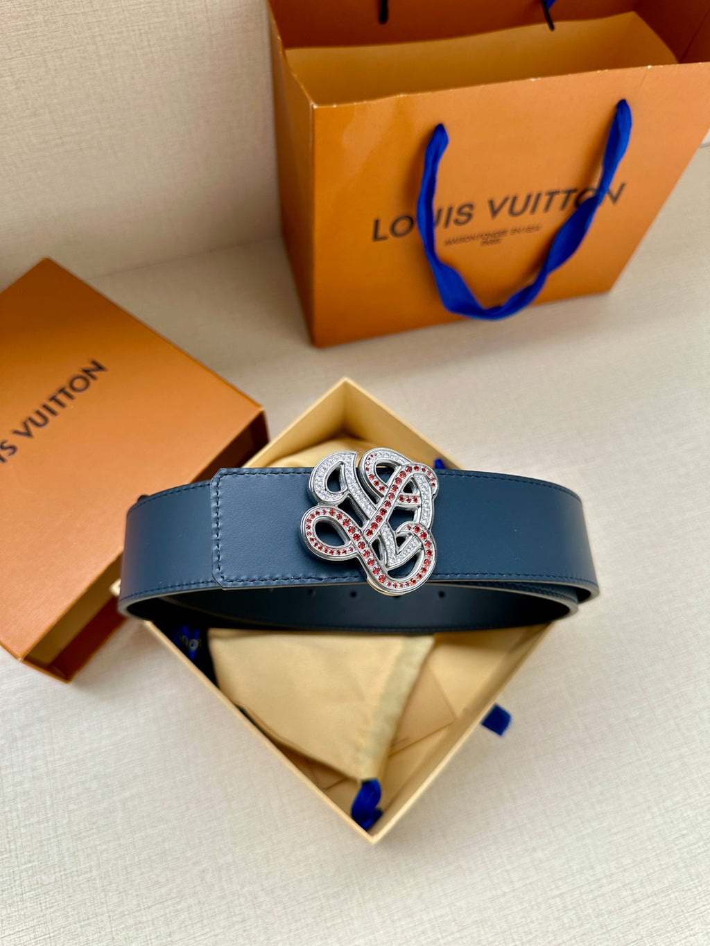 Dark blue leather belt on gift box with jeweled logo buckle
