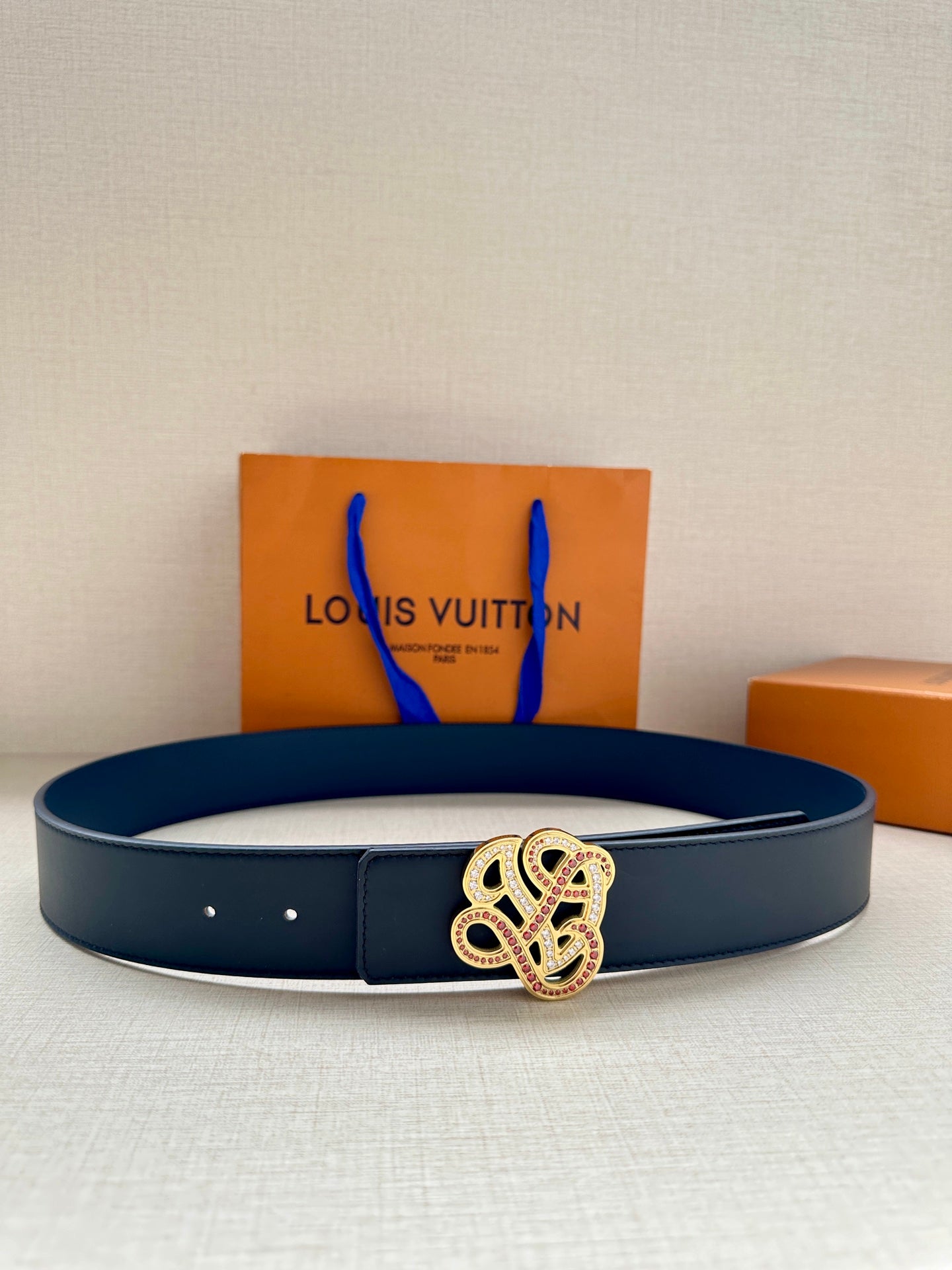 Louis Vuitton dark blue leather belt with ornate logo buckle