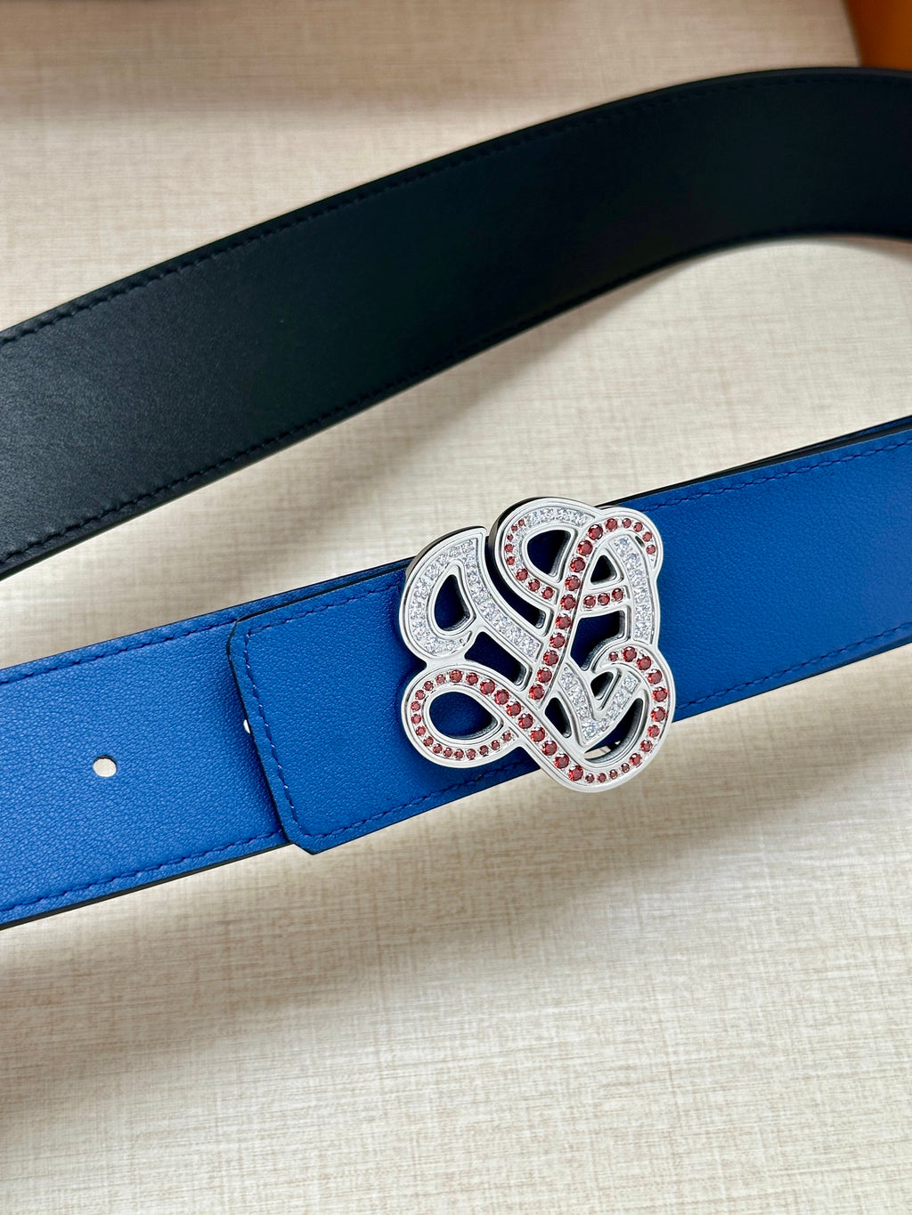 Blue leather belt strap with ornate silver and red jeweled buckle