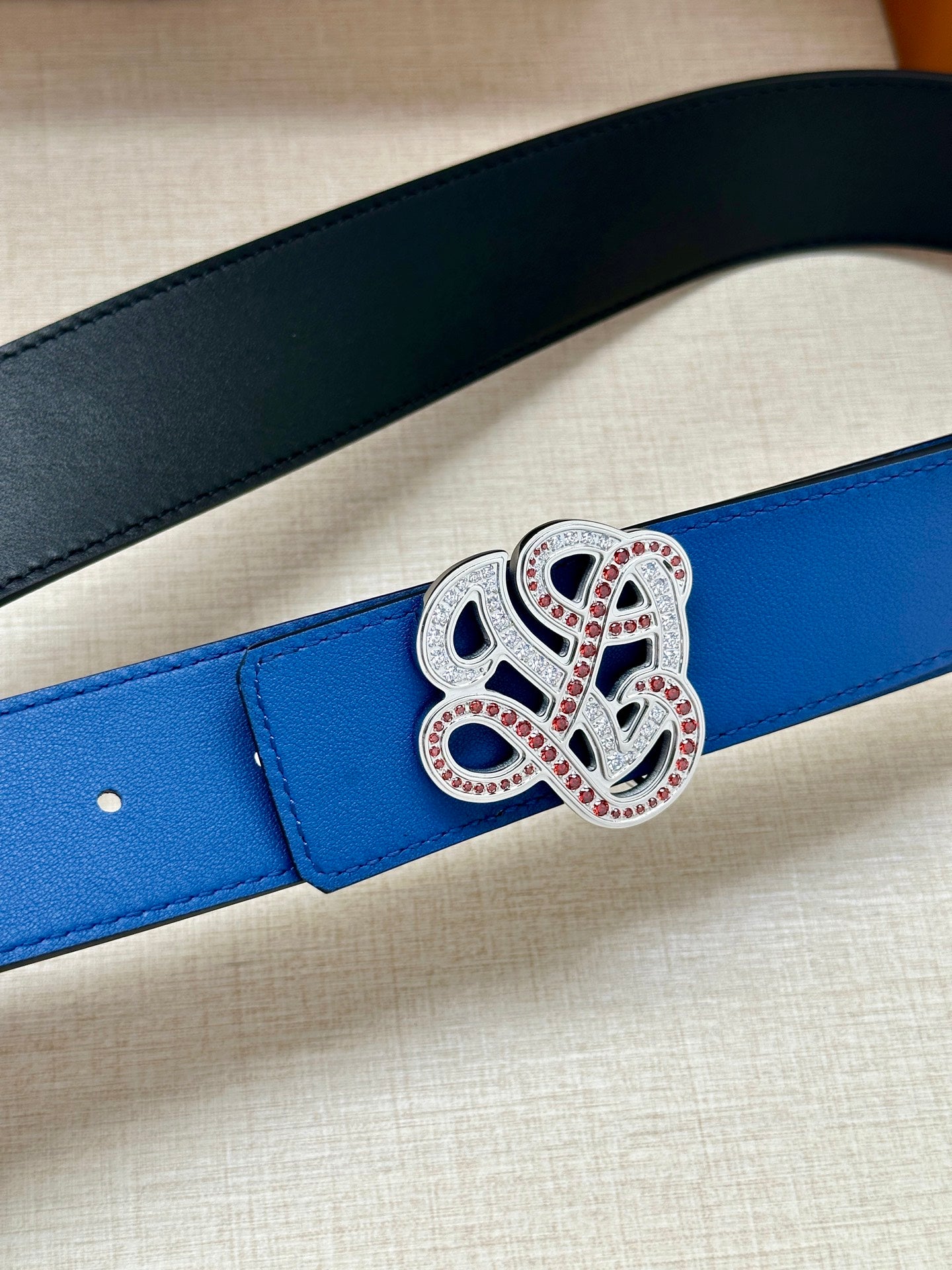 Blue leather belt strap with ornate silver and red jeweled buckle