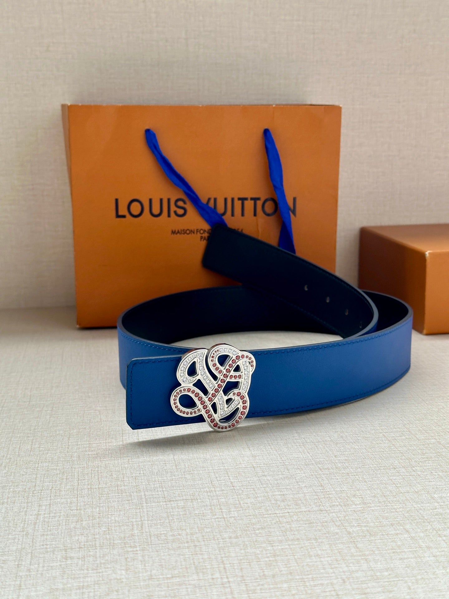 Blue leather belt with ornate buckle centered on the strap