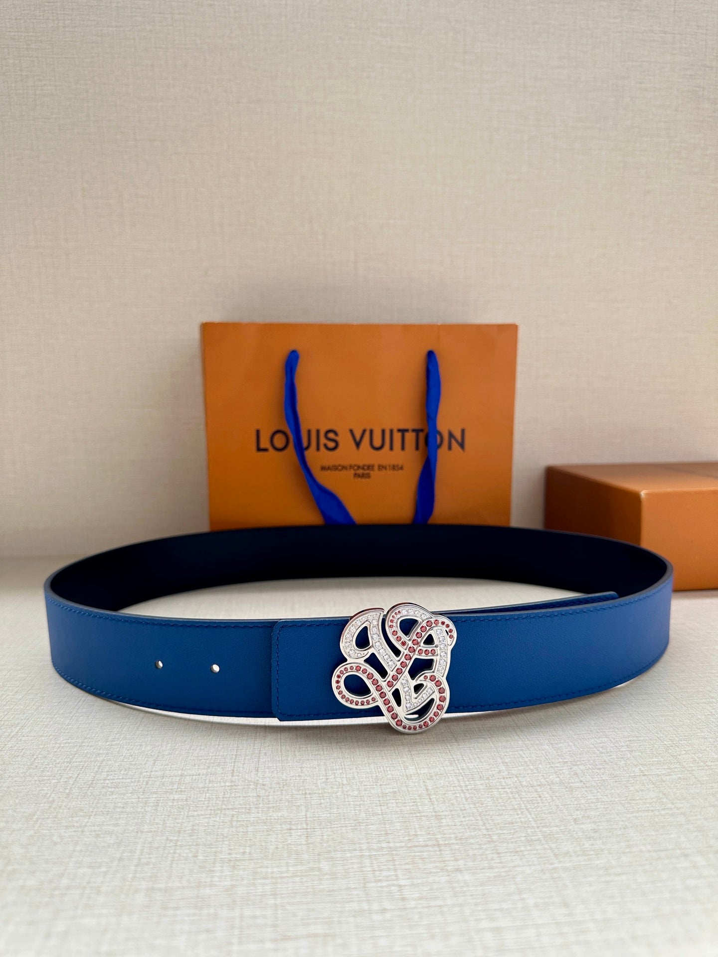 Blue leather belt with silver-toned ornate buckle detail