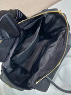Prada black bag open top with dark interior lining and gold zipper trim