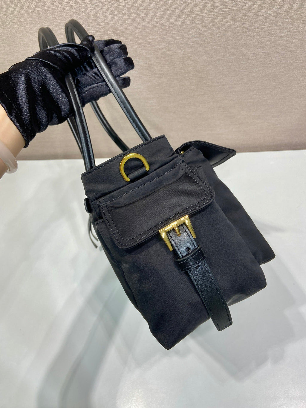 Prada black mini tote bag with front strap, gold hardware, and logo detail