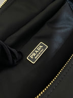 Prada label on black bag interior lining with gold text hardware