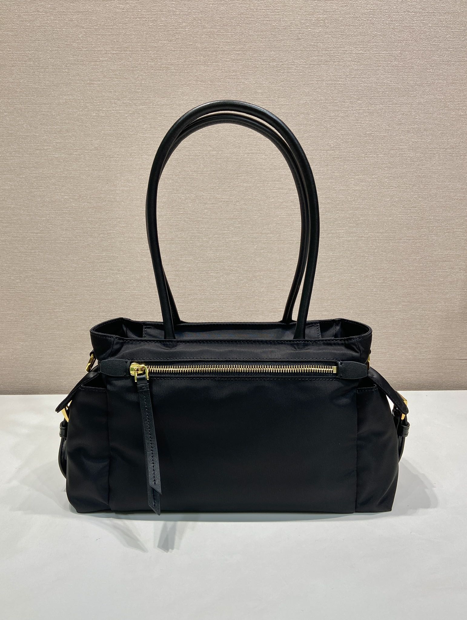 Prada black tote bag front view with top handles and gold zipper pocket