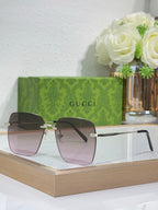 Gucci sunglasses with gold-tone frame and tinted lenses, front angle.