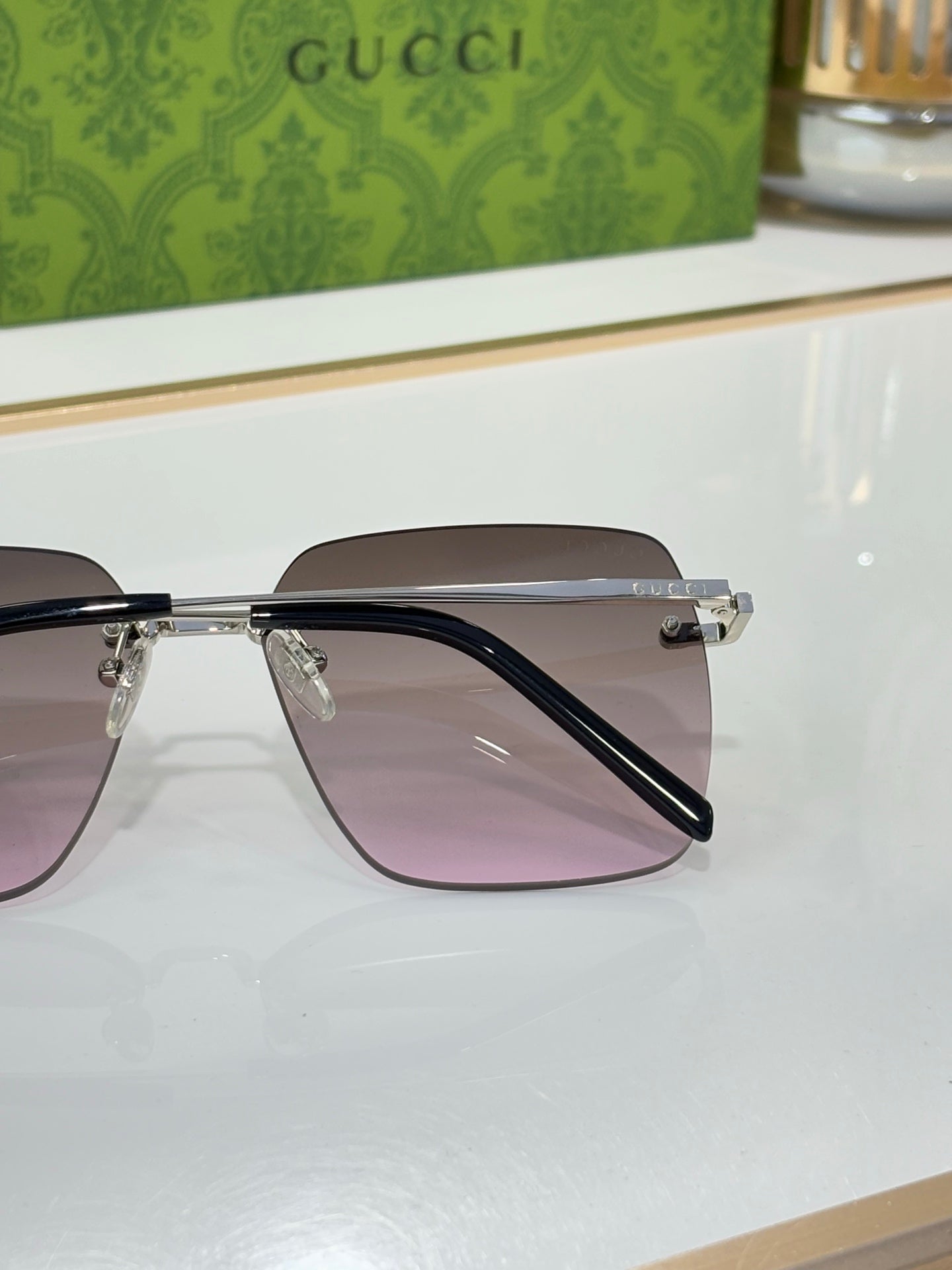 Gucci sunglasses with gold frame and tinted lenses, side profile detail.