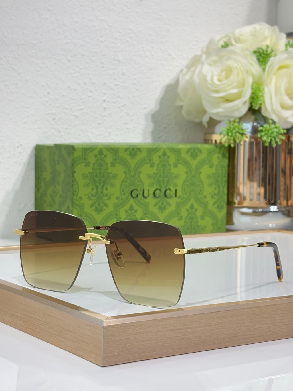 Gucci sunglasses with gold-tone frame and dark square lenses, side view.