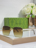 Gucci sunglasses with gold-tone frame and dark square lenses, side view.