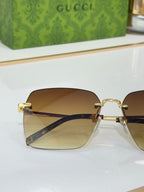 Gucci sunglasses with gold hinges and amber-gradient lenses, close side view.