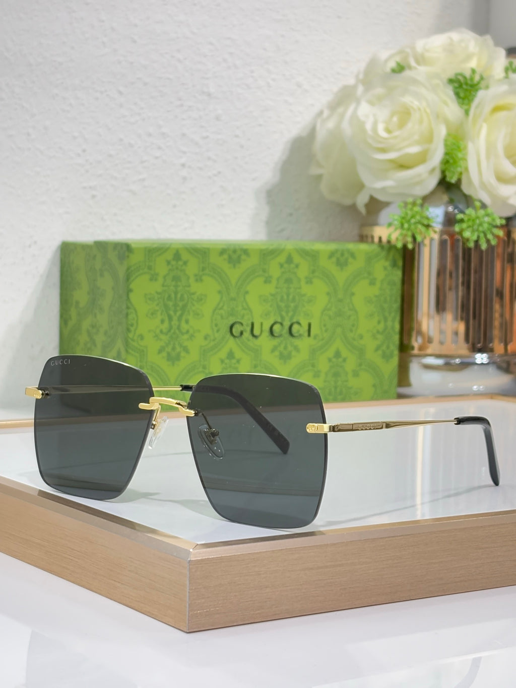 Gucci sunglasses with gold-tone frame and dark lenses, angled view.