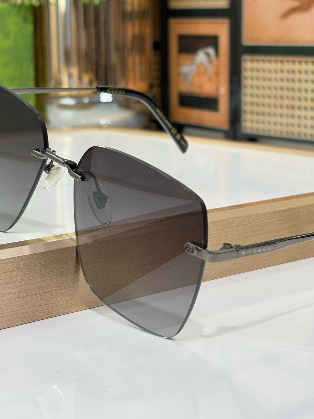 Gucci sunglasses with dark gradient lenses and metal frame, close-up side view.